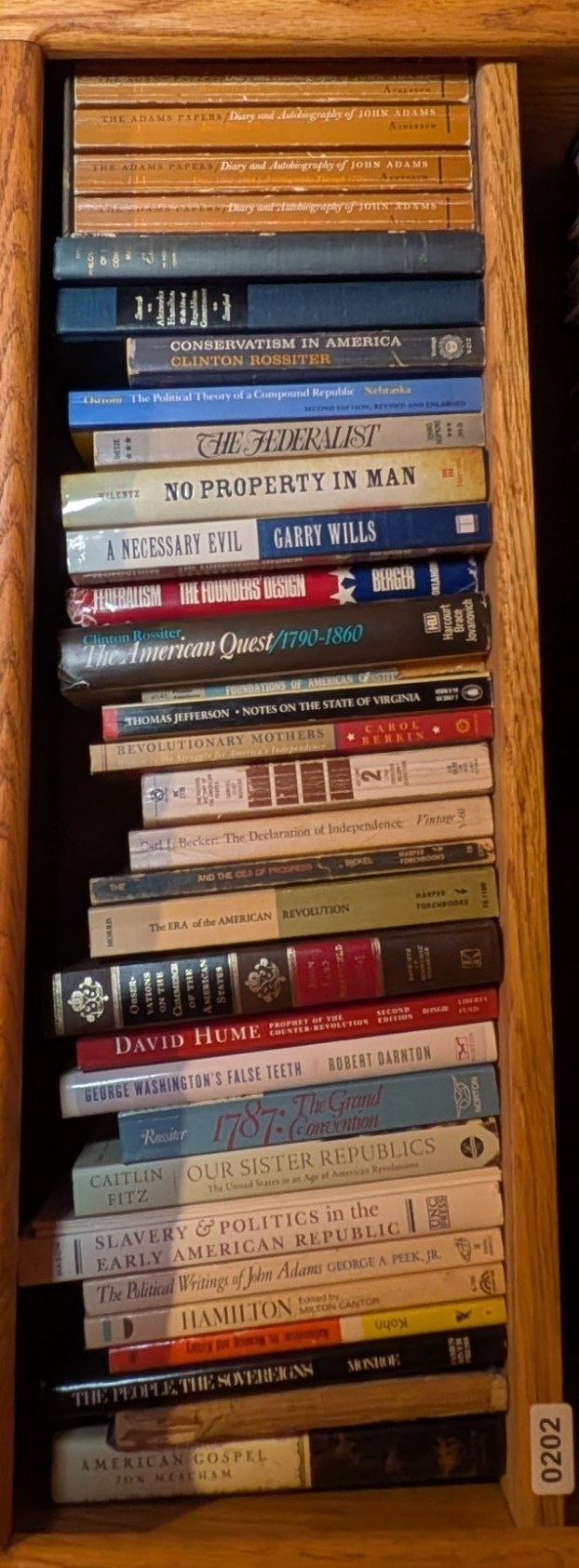 Photograph of Shelf 202 with readable book spines.