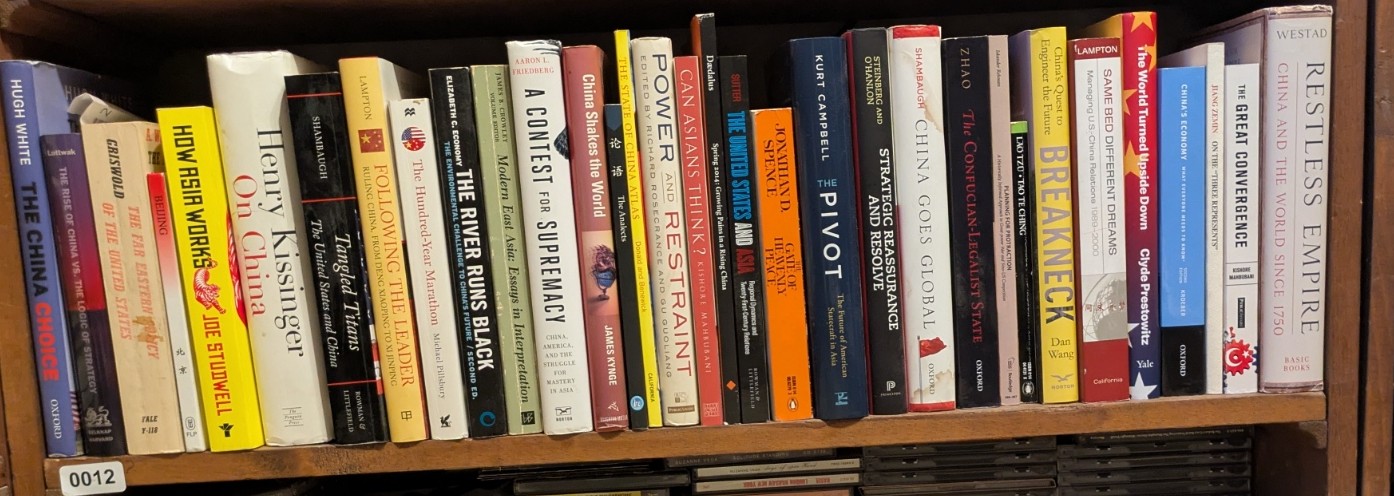 Photograph of Shelf 12; books are listed in top-to-bottom order alongside the photograph.