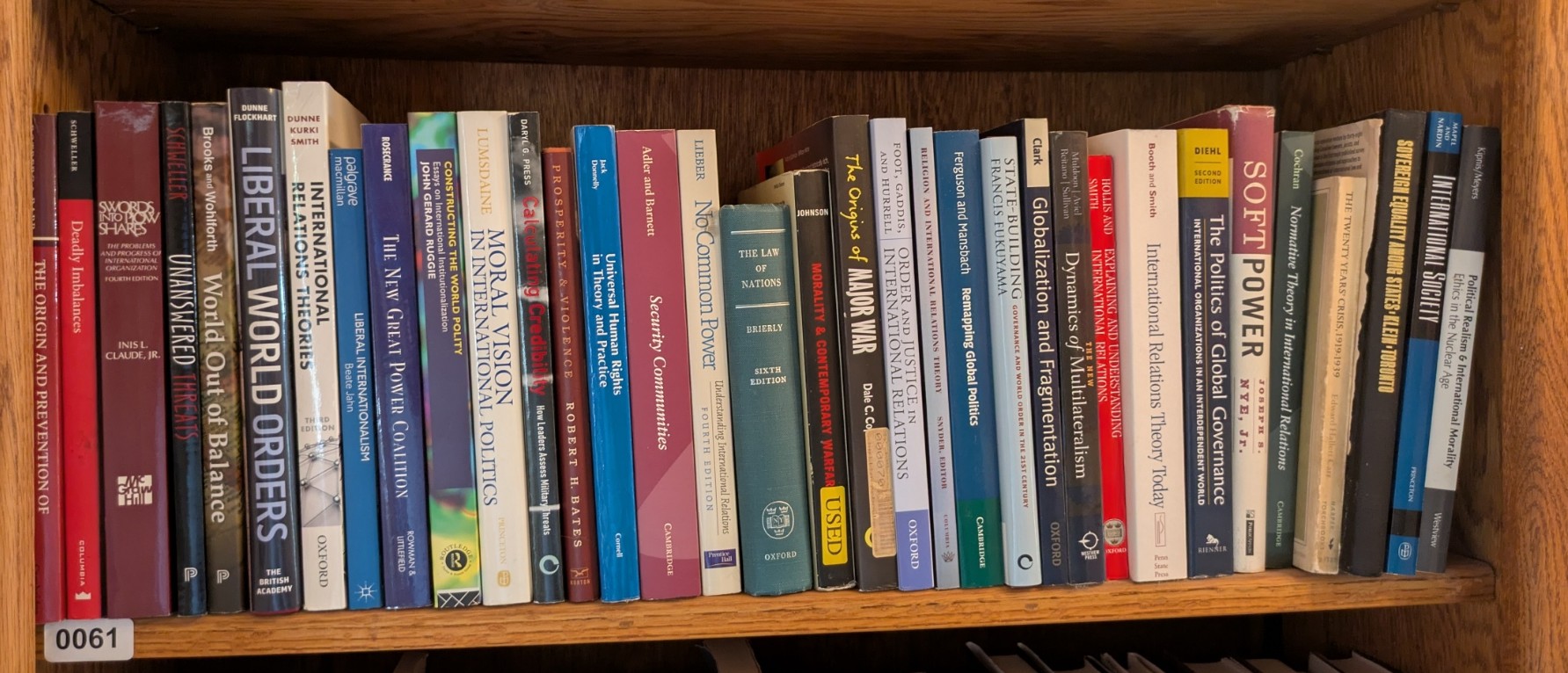 Photograph of Shelf 61; books are listed in top-to-bottom order alongside the photograph.