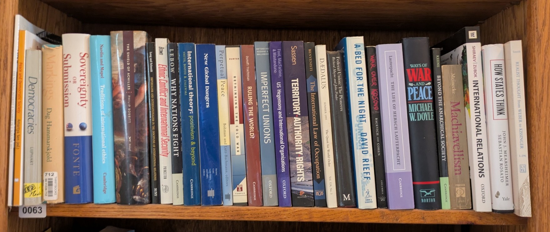 Photograph of Shelf 63; books are listed in top-to-bottom order alongside the photograph.