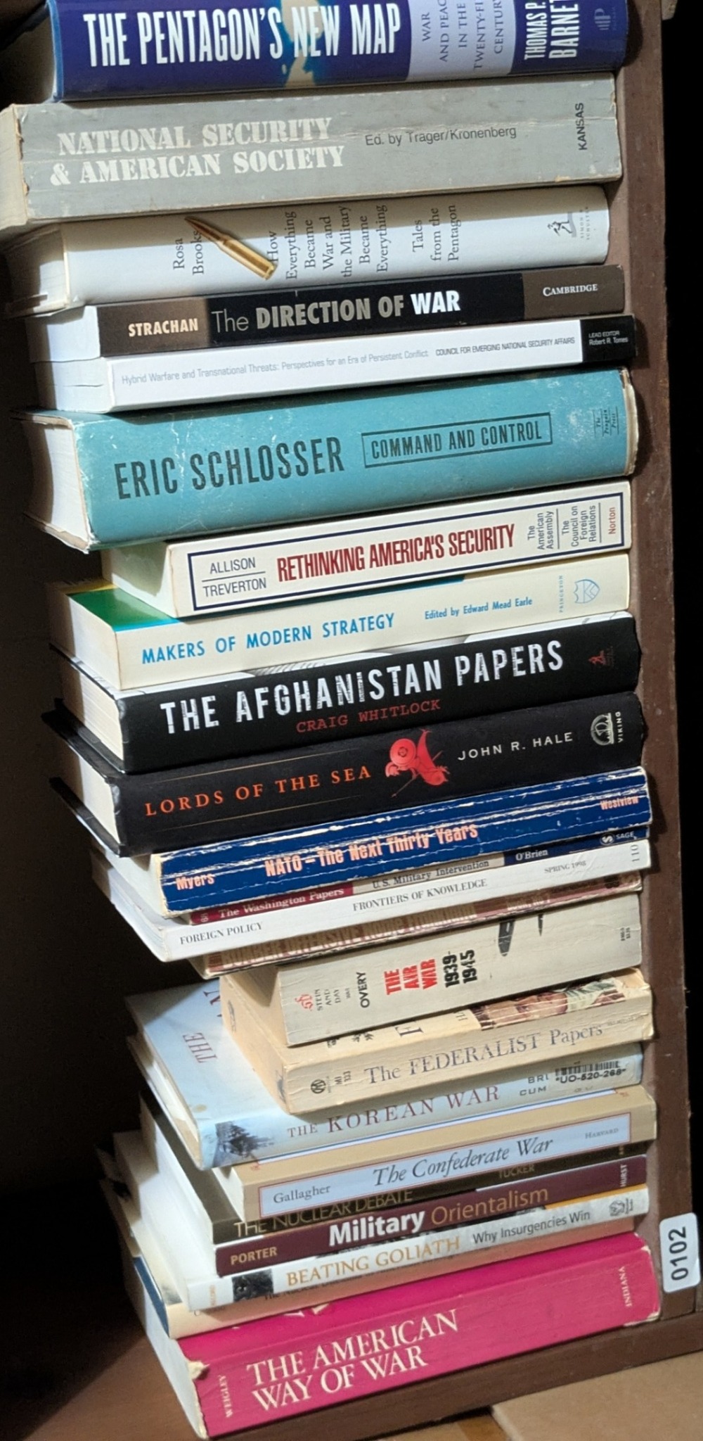 Photograph of Shelf 102; books are listed in top-to-bottom order alongside the photograph.