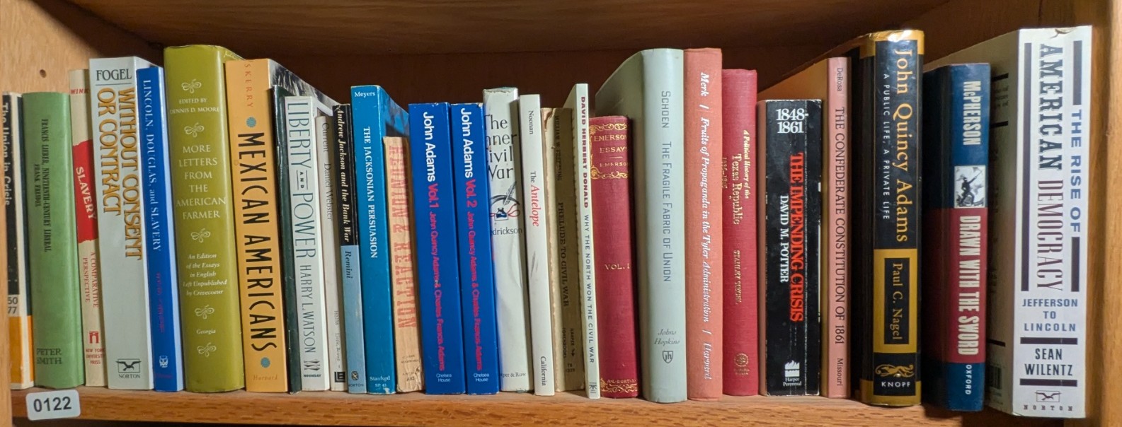 Photograph of Shelf 122; books are listed in top-to-bottom order alongside the photograph.
