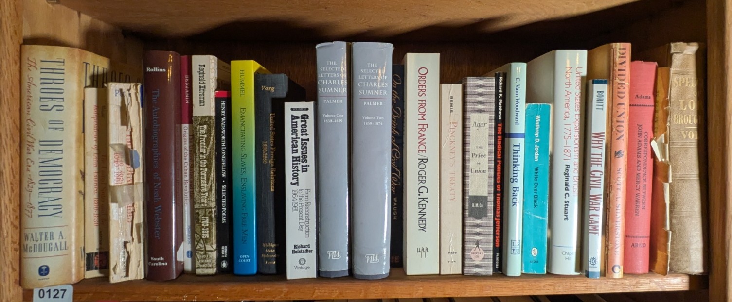 Photograph of Shelf 127; books are listed in top-to-bottom order alongside the photograph.